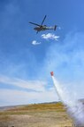 A HH-60M Black Hawk, assigned to Wyoming Army Aviation Support Facility, releases water during an interagency bucket drop training at Camp Guernsey, Wyoming, on April 16, 2025.