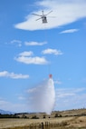 A HH-60M Black Hawk, assigned to Wyoming Army Aviation Support Facility, releases water during an interagency bucket drop training at Camp Guernsey, Wyoming, on April 16, 2025.