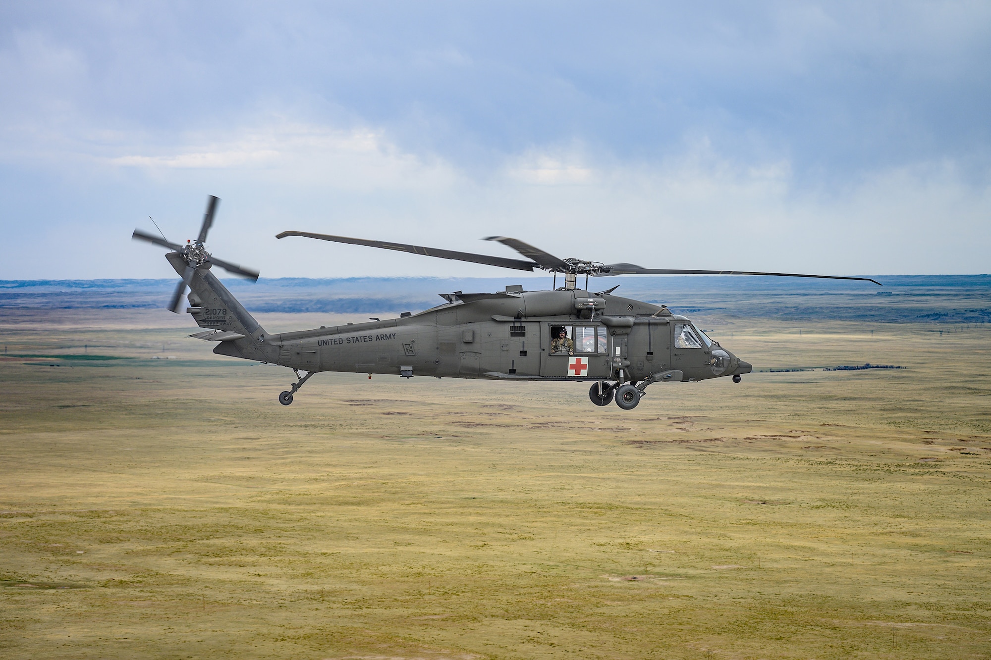 A HH-60M Black Hawk, assigned to Wyoming Army Aviation Support Facility, is airborne during an interagency bucket drop training at Camp Guernsey, Wyoming, on April 16, 2025.