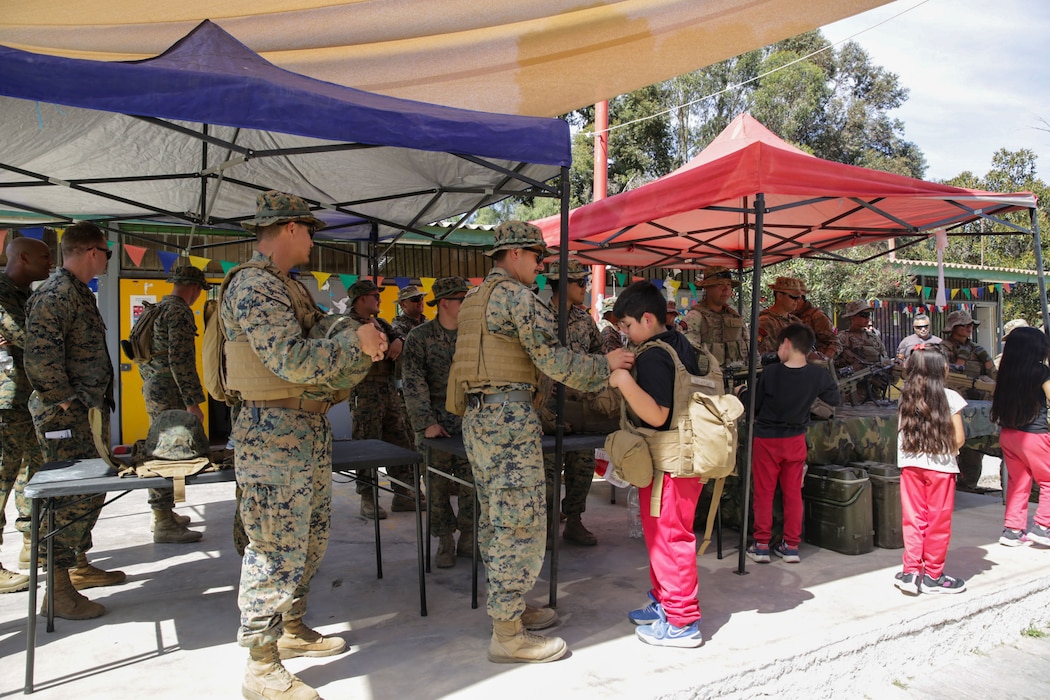 U.S. Marine Corps Sgt. Stephan Lovelace, a platoon sergeant with Marine Wing Communication Squadron 48 helps a Chilean Student put on his flak during a community relations event, at a school in, Coquimbo, Chile, on September 9, 2024. U.S. and Chilean Marines held a community relations event at a local school in Coquimbo, during UNITAS 2024, to build better relationships with the local population. UNITAS, which is Latin for “unity”, was conceived in 1959 and has taken place annually since first conducted in 1960. This year marks the 65th iteration of the world’s longest running annual multinational maritime exercise. (U. S. Marine Corps photo by Lance Cpl. Payton Goodrich)
