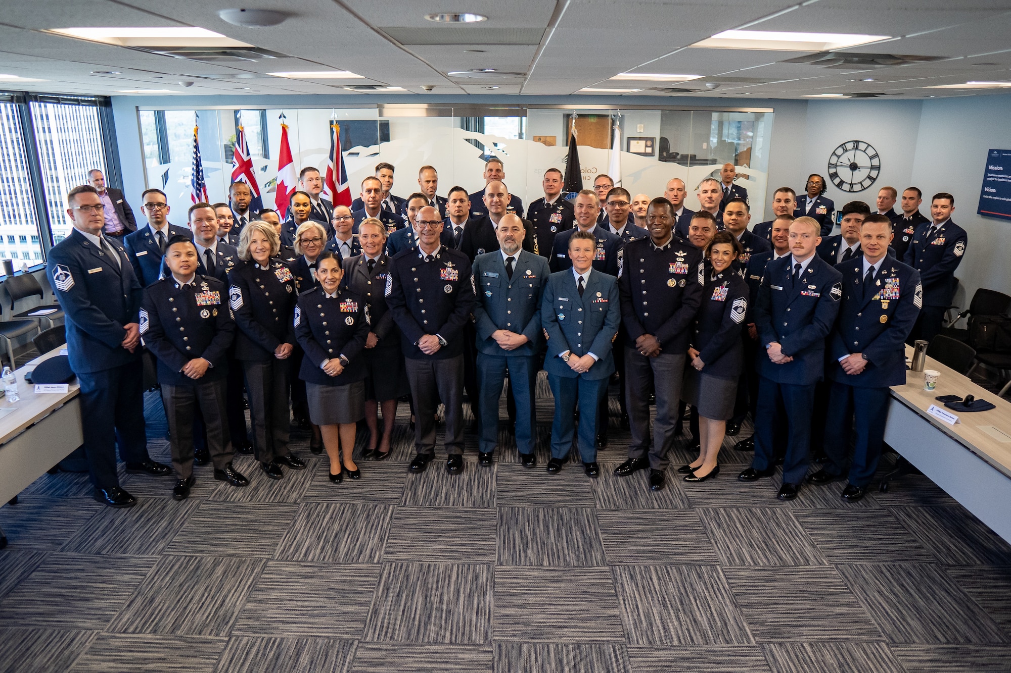Airmen and Gaurdians stand together in service dress for a group photo.