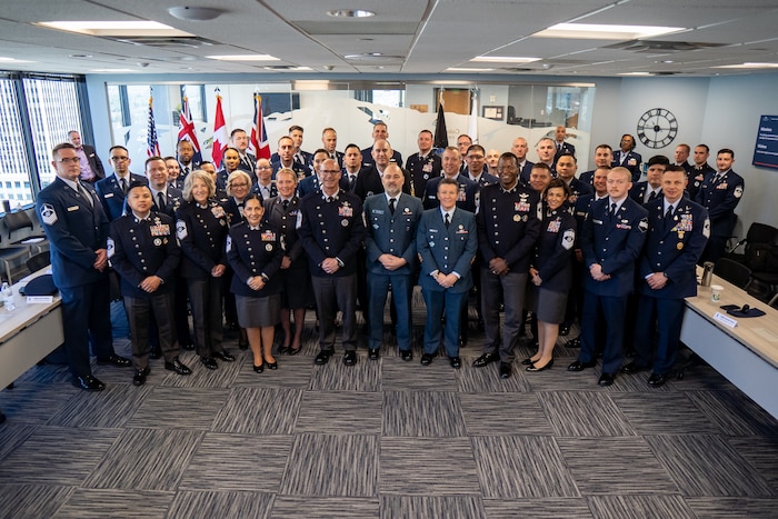 Airmen and Gaurdians stand together in service dress for a group photo.