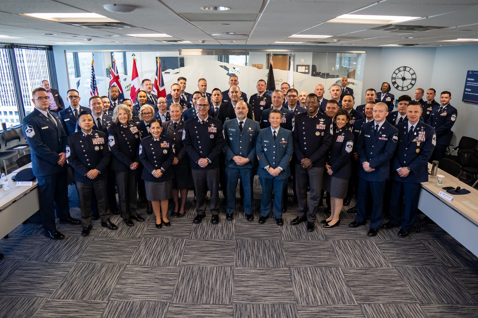 Airmen and Gaurdians stand together in service dress for a group photo.
