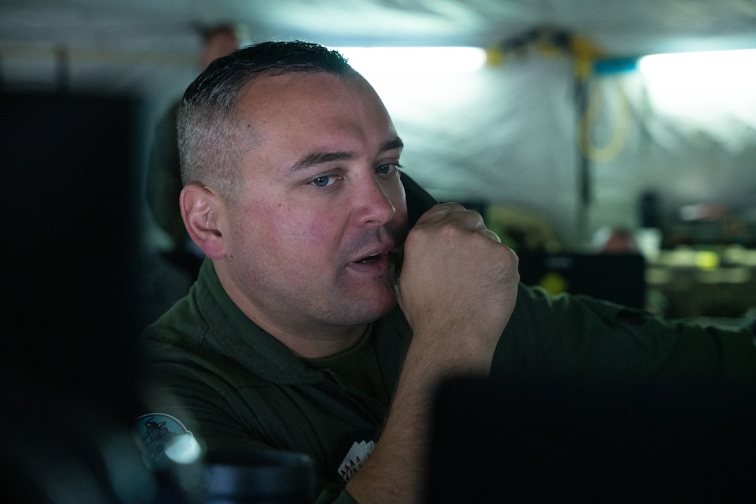 U.S. Marine Capt. Benjamin Meisner, fixed and rotary wing frag officer with Marine Tactical Air Command Squadron (MTACS) 48, 4th Marine Aircraft Wing, communicates critical information in a simulated mission scenario during Northern Lightning 23 at Volk Field Air National Guard Base, Wisconsin, Aug. 13, 2023. Northern Lightning is one of the seven Air National Guard joint accredited readiness exercises that increases military readiness by providing participating units a tactical, joint training environment to execute realistic combat training. (U.S. Marine Corps photo by Cpl. Ujian Gosun)