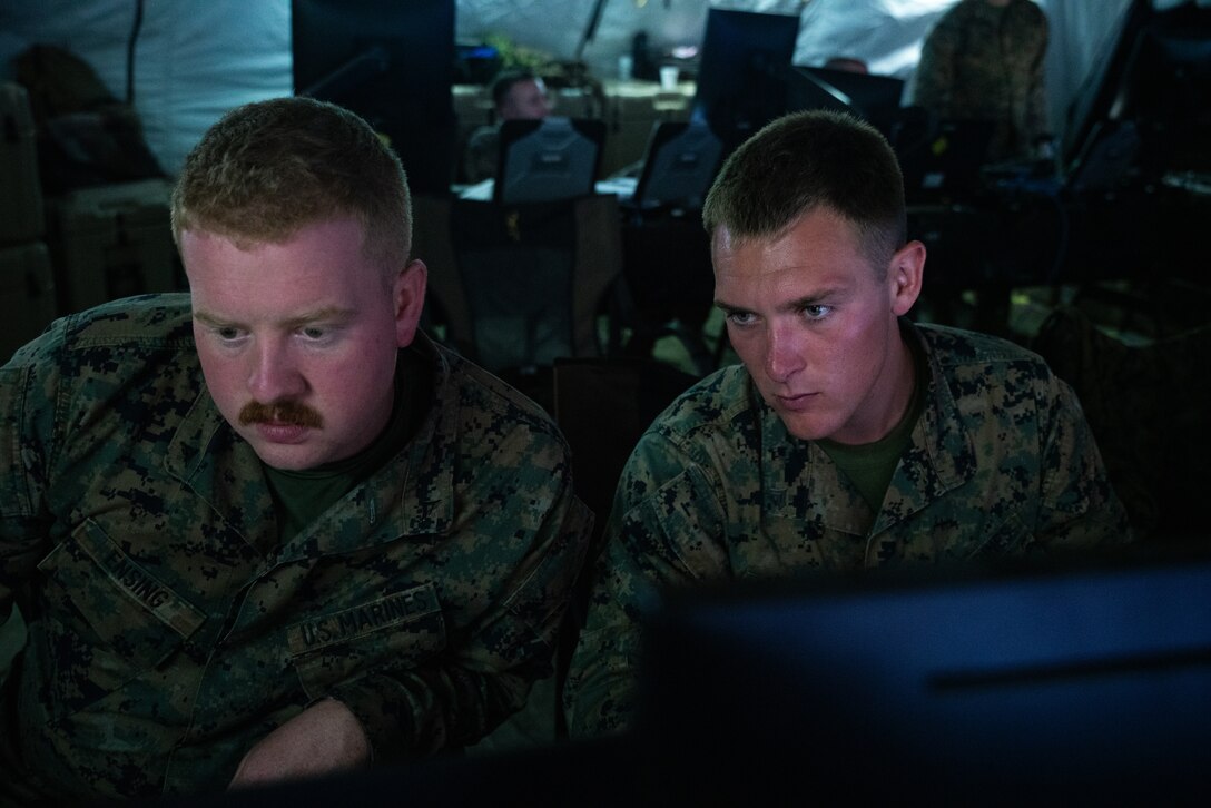U.S. Marine Lance Cpl. Joshua Ensing, left, a tactical air defense controller, and Cpl. Adam Shattuck, an air support operations operator, both with Marine Tactical Air Command Squadron (MTACS) 48, 4th Marine Aircraft Wing, participate in various simulated mission scenarios during Northern Lightning 23 at Volk Field Air National Guard Base, Wisconsin, Aug. 14, 2023. Northern Lightning is one of the seven Air National Guard joint accredited readiness exercises that increases military readiness by providing participating units a tactical, joint training environment to execute realistic combat training. Ensing is a native of Stevens Point, Wisconsin. Shattuck is a native of McHenry, Illinois. (U.S. Marine Corps photo by Cpl. Ujian Gosun)