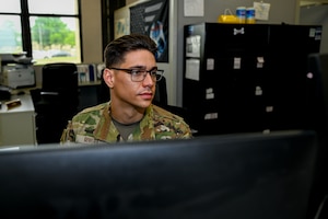 U.S. Air Force Senior Airman Joseph Rivera, 42nd Logistics Readiness Squadron passenger travel technician, works on a computer at his desk at Maxwell Air Force Base, Alabama, April 24, 2025.
