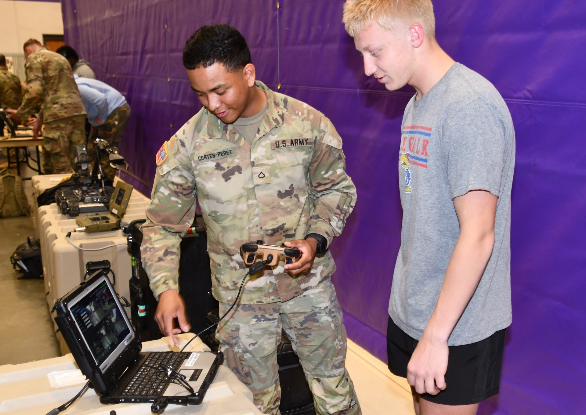 A U.S. Army Explosive Ordnance Disposal (EOD) Soldier from the 1st Infantry Division demonstrates a robotic control system to a student during a STEM engagement event at Spring Hill High School in Spring Hill, Kansas. The interactive exhibit showcased how technology and innovation are essential to modern Army careers.