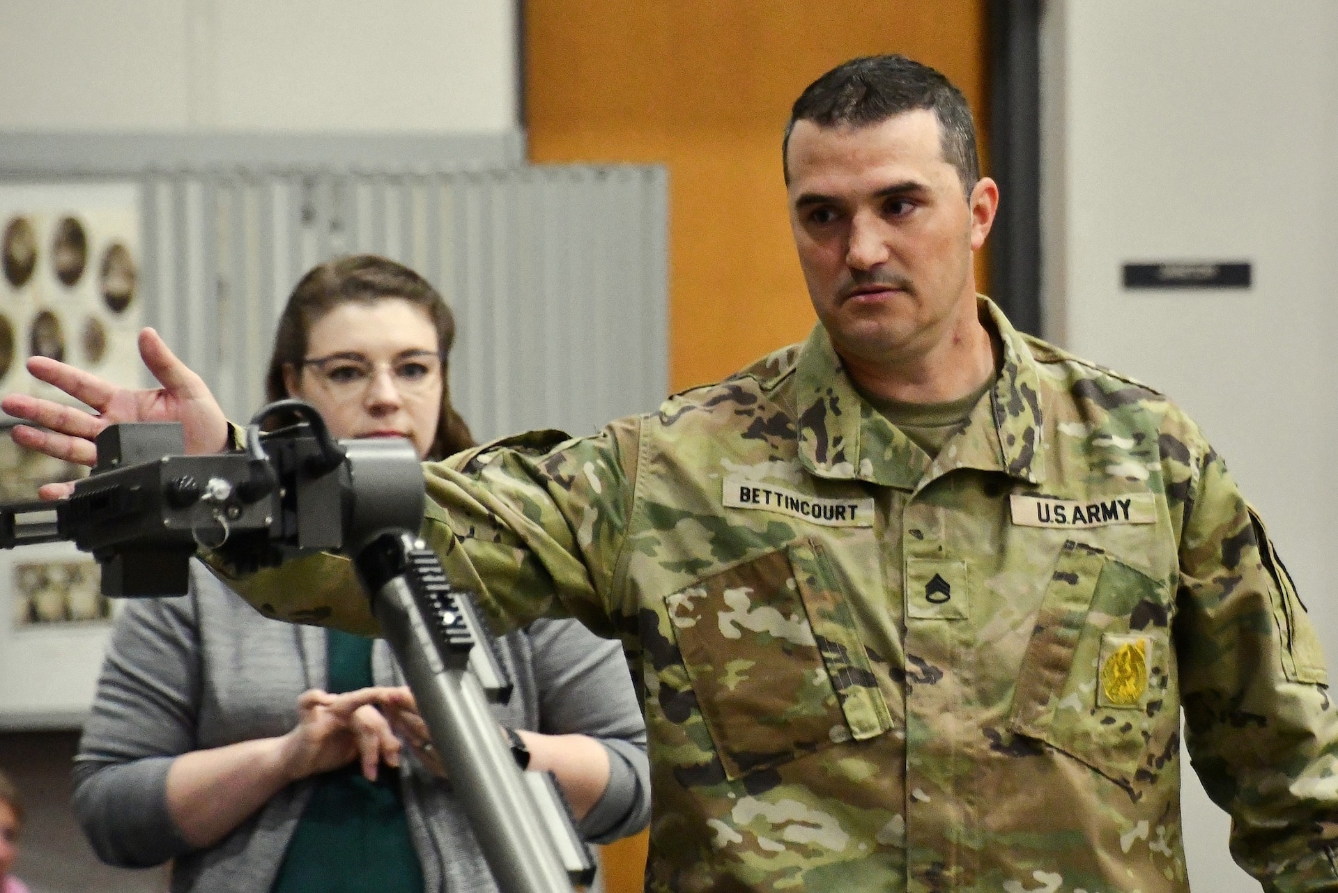 Staff Sergeant Bettincourt, station commander of the Overland Park Army Recruiting Station, explains the functions of a robotic arm used by Explosive Ordnance Disposal (EOD) teams during a STEM-focused Army demonstration at Spring Hill High School in Spring Hill, Kansas. The event highlighted the role of advanced technology in modern Army careers.