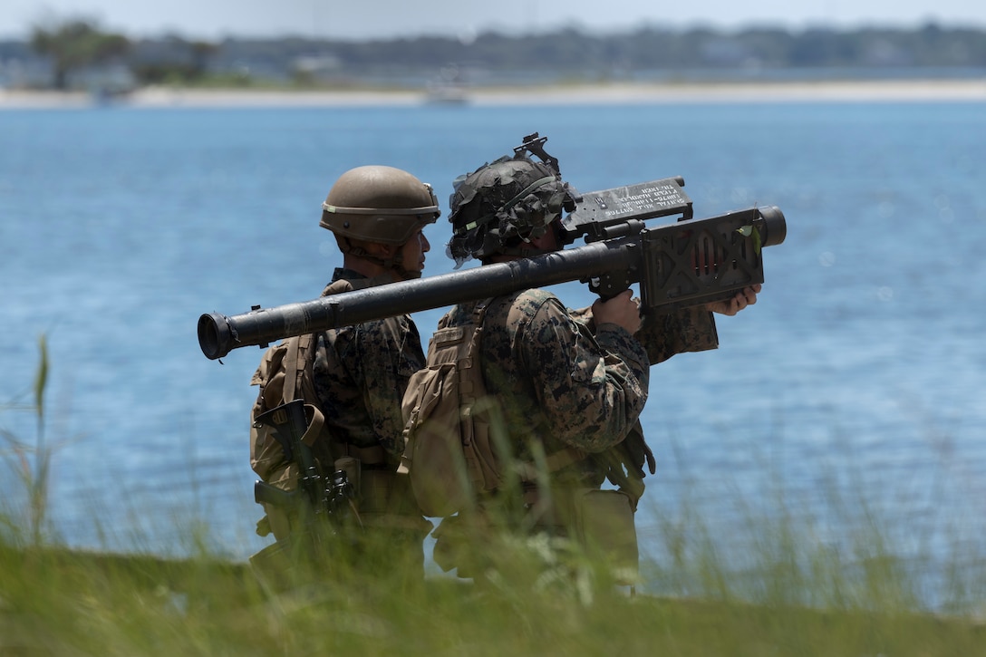 U.S. Marine Corps Lance Cpl. Vernal Emhoolah, left, a native of Texas, and Pfc. Kyle VanSteenbergen, a native of North Carolina, both low-altitude air-defense gunners with 2nd Low Altitude Air Defense (LAAD) Battalion, Marine Air Control Group (MACG) 28, 2nd Marine Aircraft Wing (MAW), aim a simulated FIM-92 Stinger missile during a Base Defense Zone (BDZ) exercise at Marine Corps Auxiliary Landing Field Bogue, North Carolina, June 11, 2024. Marines from 2nd LAAD, MACS-24 and Marine Wing Support Squadron (MWSS) 271 executed this exercise to enhance confidence and proficiency in BDZ operations. (U.S. Marine Corps photo by Lance Cpl. Bryan Giraldo)