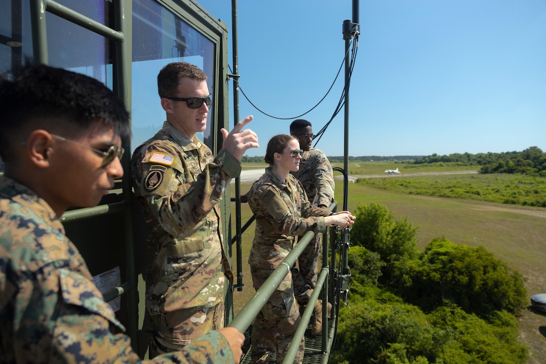 U.S. Army Warrant Officer Kevin McCloskey, native of Minnesota with 1st Attack Battalion, 82nd Combat Aviation Brigade, talks to service members during a Base Defense Zone (BDZ) exercise at Marine Corps Auxiliary Landing Field Bogue, North Carolina, June 11, 2024. Marines from 2nd Low Altitude Air Defense (LAAD) Battalion, Marine Air control Squadron (MACS) 24 and Marine Wing Support Squadron (MWSS) 271 executed this exercise to enhance confidence and proficiency in BDZ operations. (U.S. Marine Corps photo by Lance Cpl. Bryan Giraldo)