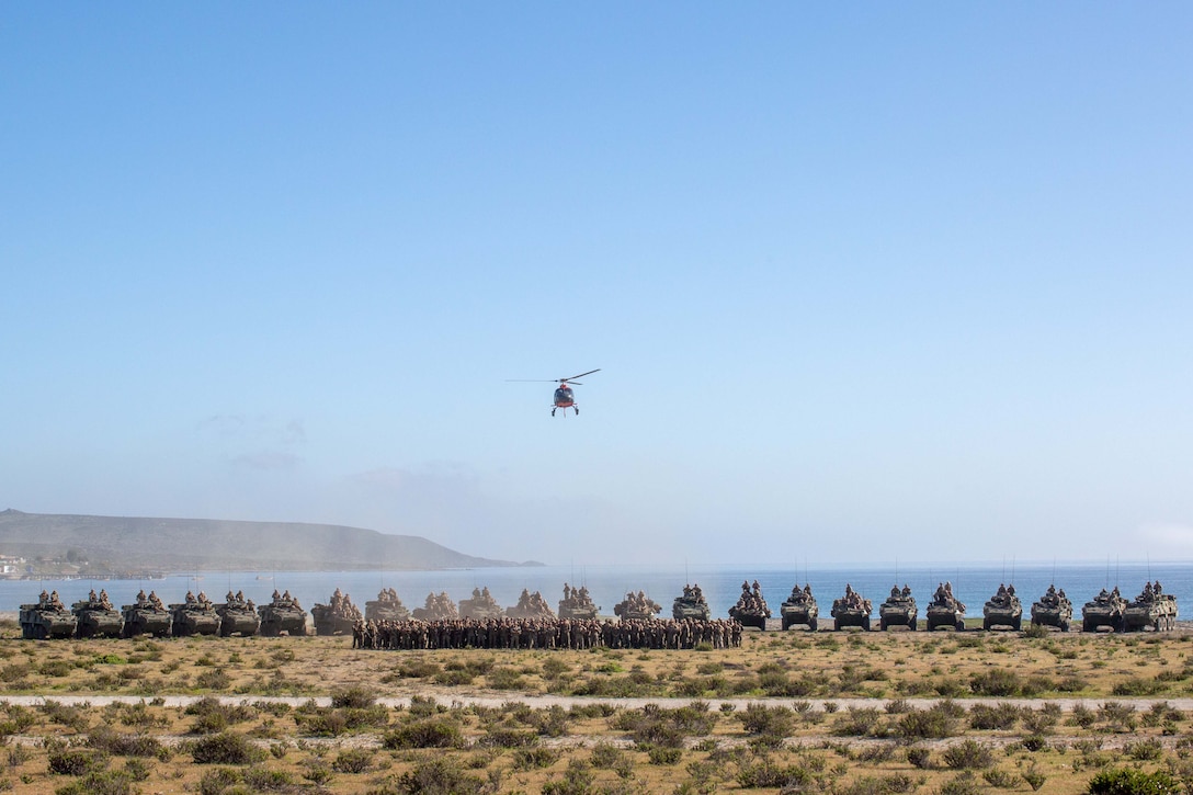 U.S. Marines from 4th Light Armored Reconnaissance Battalion, 2nd Battalion 7th Marines and Marine Air Support Squadron 6, pose with Chilean Marines in front of U.S. and Chilean Marine Corps Light Armored Vehicles at an Expeditionary Advanced Base in Puerto Aldea, Chile, on Sept. 6, 2024, while participating in Exercise UNITAS LXV. The U.S. and Chilean Marines took a group photo to commemorate their combined training at UNITAS LXV and to celebrate the partnership between the countries. UNITAS focuses on strengthening our existing regional partnerships and encouraging new relationships through the exchange of maritime mission-focused knowledge and expertise. (U. S. Marine Corps photo by Lance Cpl. Payton Goodrich)