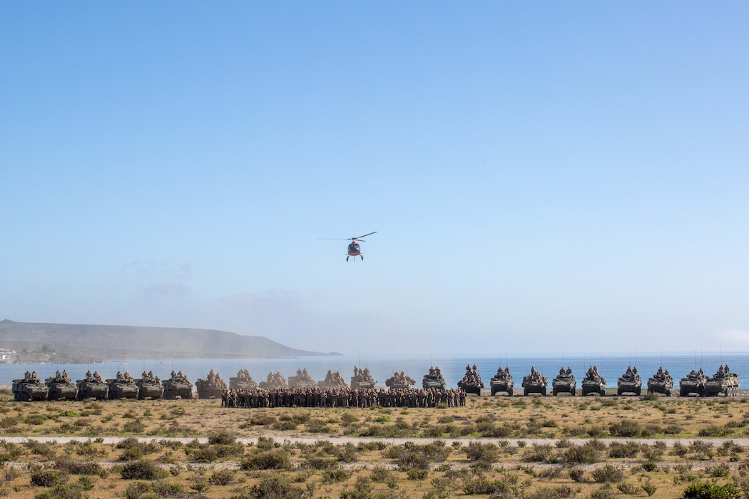 U.S. Marines from 4th Light Armored Reconnaissance Battalion, 2nd Battalion 7th Marines and Marine Air Support Squadron 6, pose with Chilean Marines in front of U.S. and Chilean Marine Corps Light Armored Vehicles at an Expeditionary Advanced Base in Puerto Aldea, Chile, on Sept. 6, 2024, while participating in Exercise UNITAS LXV. The U.S. and Chilean Marines took a group photo to commemorate their combined training at UNITAS LXV and to celebrate the partnership between the countries. UNITAS focuses on strengthening our existing regional partnerships and encouraging new relationships through the exchange of maritime mission-focused knowledge and expertise. (U. S. Marine Corps photo by Lance Cpl. Payton Goodrich)