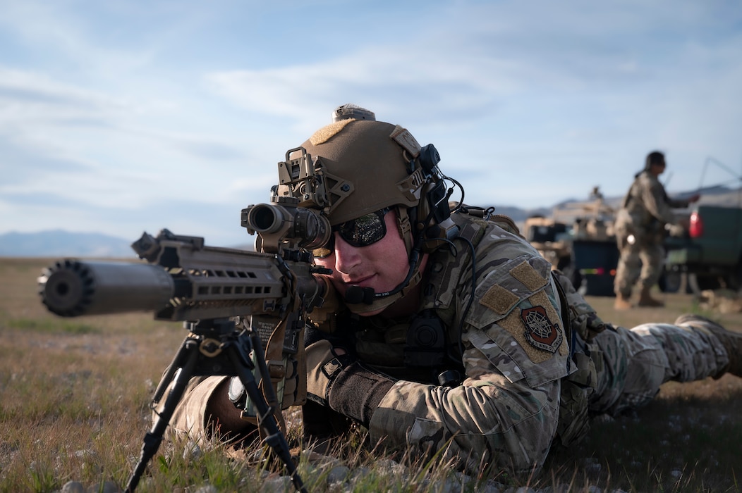 Man aims down scope of sniper rifle
