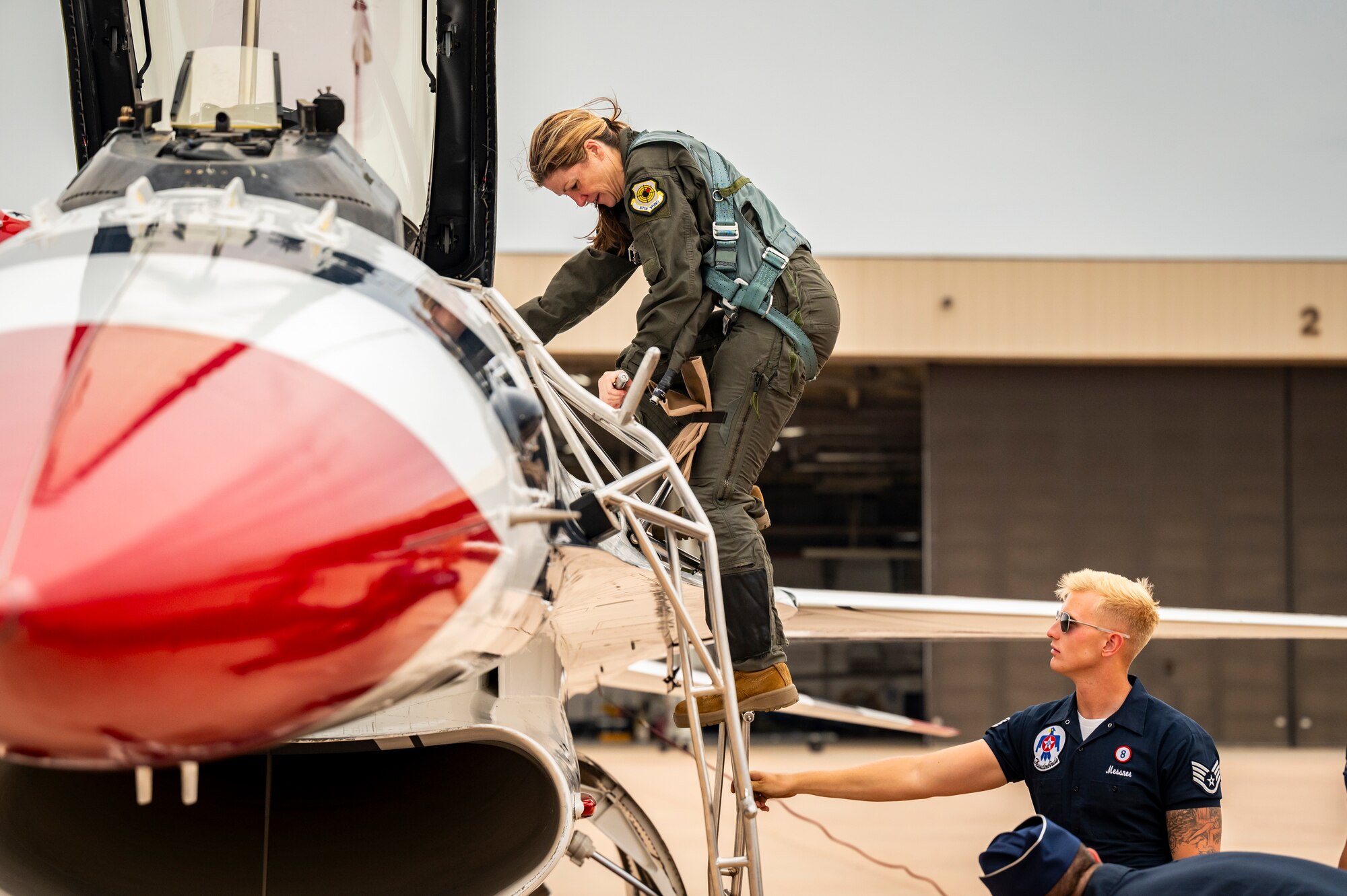 Cari Selzer, Hometown Hero participant, climbs out of the cockpit of a F-16 Fighting Falcon, with assistance from U.S. Air Force Staff Sgt. Chase Messner, a Fighter Aircraft Integrated Avionics specialist for the U.S. Air Force Air Demonstration Squadron "Thunderbirds", after an incentive flight with the Thunderbirds at Dyess Air Force Base, Texas, April 18, 2025. Selzer is a dedicated nurse practitioner with 30 years of experience. Her unwavering commitment to serving others, both locally and internationally, spans from life-saving emergency interventions, to consistent volunteer work, and nursing education. Her actions and career embodies the spirit of compassion and service. (U.S. Air Force photo by Staff Sgt. Leon Redfern)