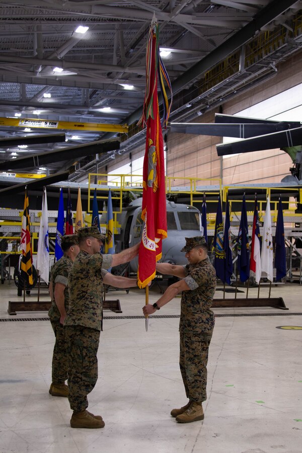 U.S. Marine Corps Sgt. Maj. Luis R. Salavarria, right, sergeant major, passes the battalion colors to Lt. Col. Jeffery G. Dean, outgoing commanding officer, Marine Aviation Logistics Squadron 49 (MALS-49), Marine Aircraft Group 49, 4th Marine Air Wing, during the MALS-49 change of command ceremony on Marine Corps Air Station New River, in Jacksonville, North Carolina, April 12, 2025. The change of command ceremony represents the transfer of responsibility, authority, and accountability from the outgoing commanding officer to the incoming commanding officer. (U.S. Marine Corps photo by Lance Cpl. Hunter Brock)
