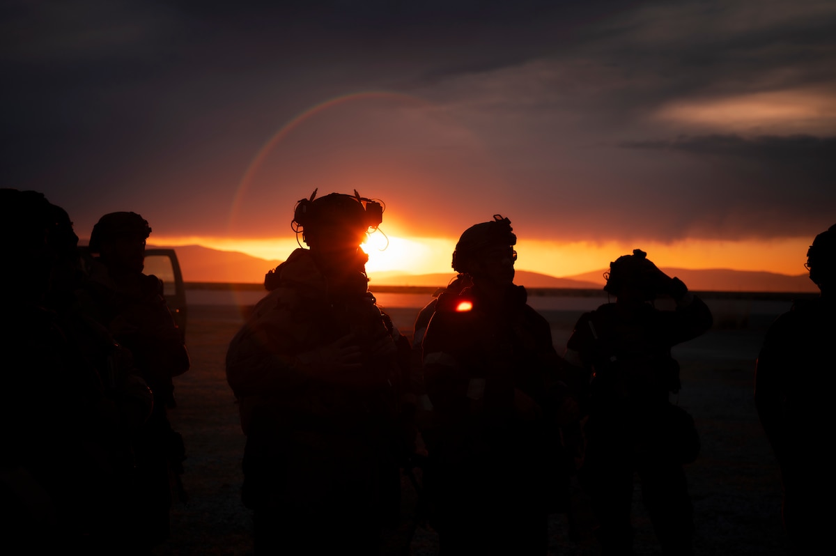 Military personnel standing by at sunset