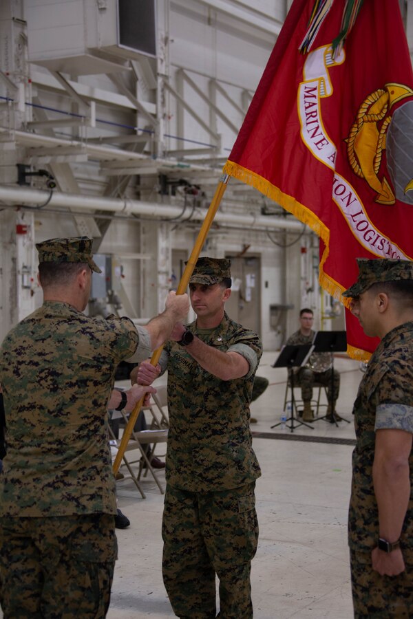 U.S. Marine Corps Lt. Col. Jefferey G. Dean, left, outgoing commanding officer, passes the battalion colors to Lt. Col. David A. Goodman, incoming commanding officer, Marine Aviation Logistics Squadron 49 (MALS-49), Marine Aircraft Group 49, 4th Marine Air Wing, during the MALS-49 change of command ceremony on Marine Corps Air Station New River, in Jacksonville, North Carolina, April 12, 2025. The change of command ceremony represents the transfer of responsibility, authority, and accountability from the outgoing commanding officer to the incoming commanding officer. (U.S. Marine Corps photo by Lance Cpl. Hunter Brock)