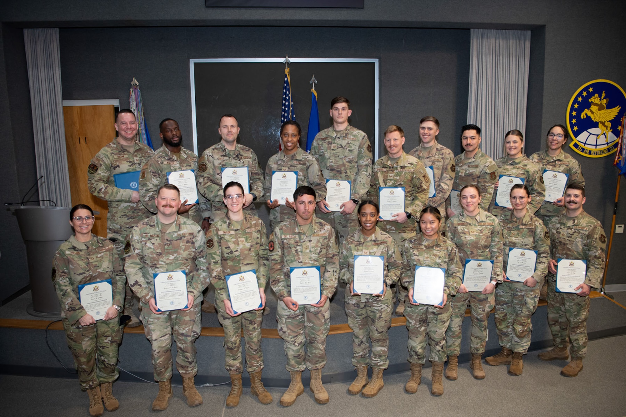 Newly inducted Staff Sergeants pose for a group photo, holding their certificates of recognition.