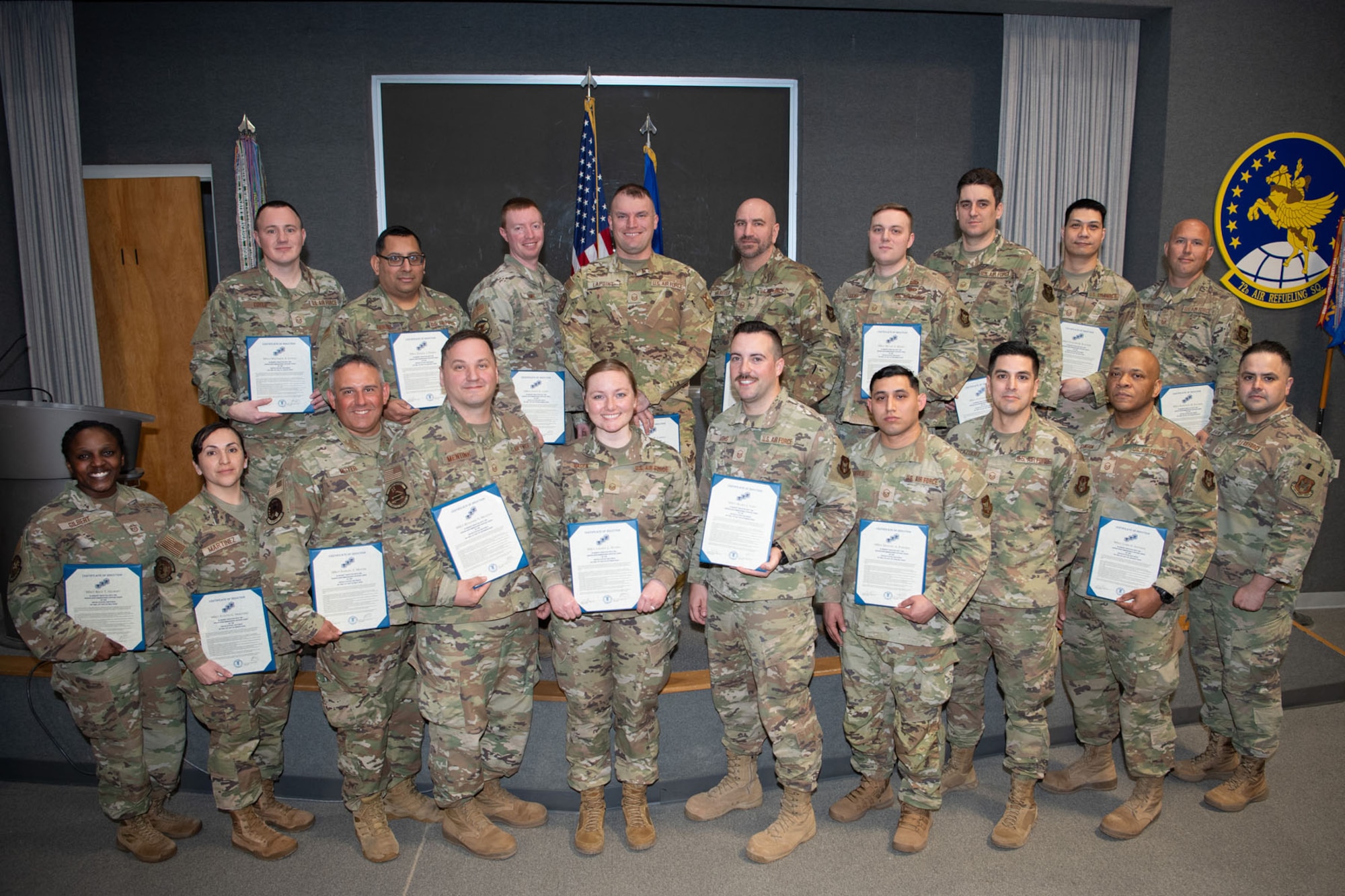 Newly inducted Master Sergeant pose for a group photo, holding their certificates of recognition.