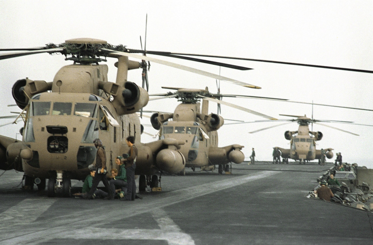 Helicopters are aboard an aircraft carrier.