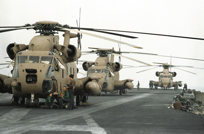 Helicopters are aboard an aircraft carrier.