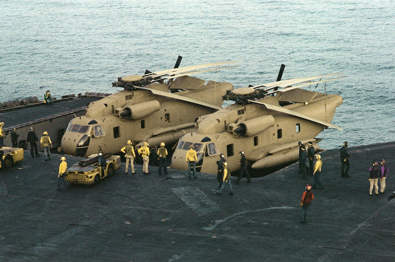 Helicopters are on an aircraft carrier.
