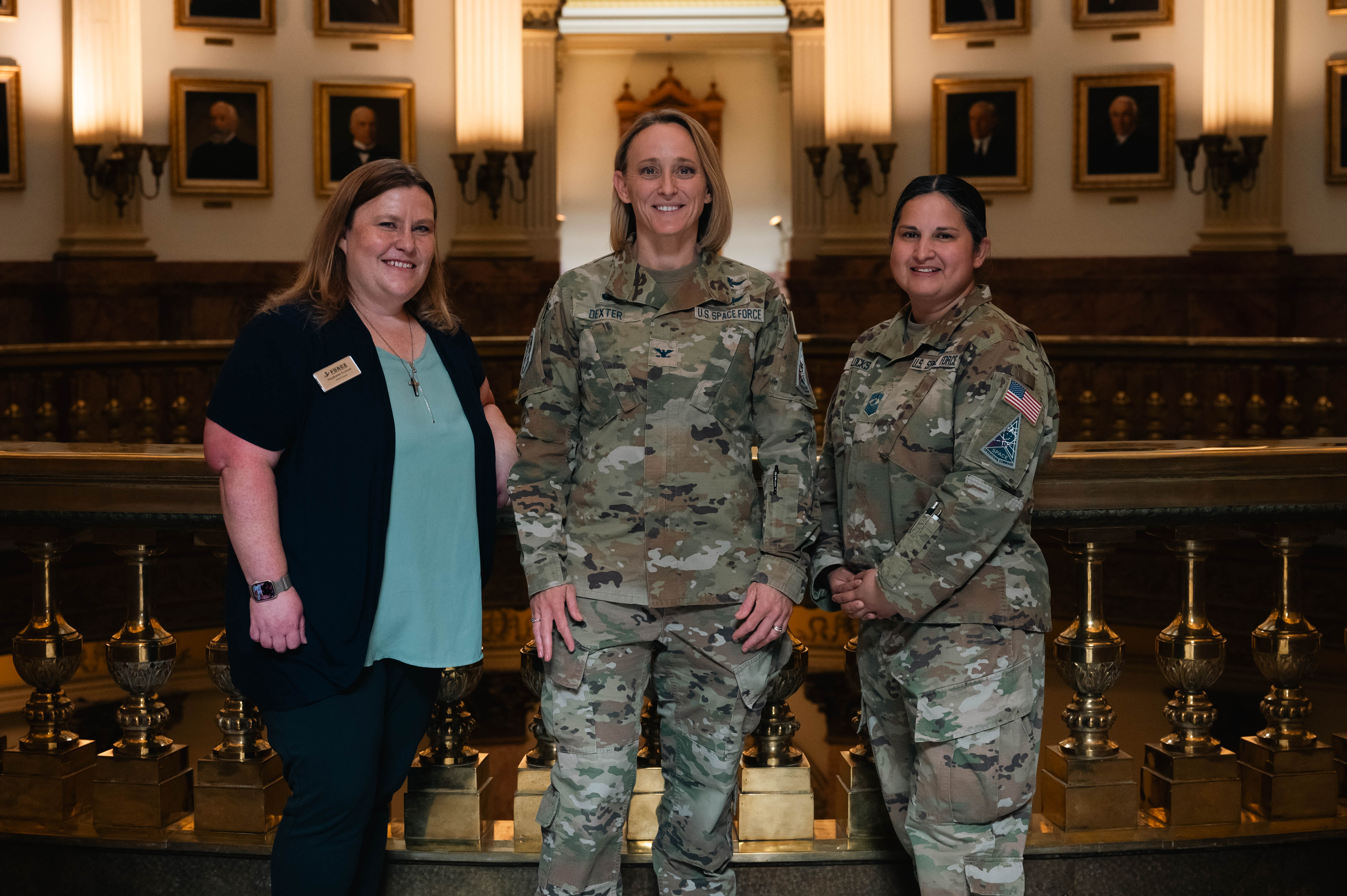 Ms. Stephanie Iverson, Buckley Space Force Base School liaison, U.S. Space Force Col. Heidi Dexter, Space Base Delta 2 commander and U.S. Space Force Chief MSgt. Marlene Locks, SBD 2 Senior Enlisted Leader, pose for a photo after the signing of the SB25-073 into law at the Colorado State Capitol Building, Denver, Colorado on Thursday, April 17. SB25-073 mandates that local education providers actively inform military families about their rights and available special education services. (U.S. Space Force photo by Staff Sgt. Danielle McBride)