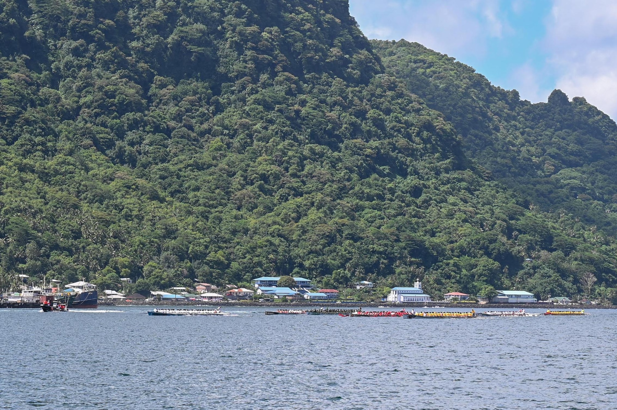 Fautasi teams race through the waters of a Pago Pago Harbor during the 125th American Samoa Flag Day celebration in Pago Pago, American Samoa, April 16, 2025. Each team represented months of preparation, driven by community pride and the pursuit of shared victory. (U.S. Air Force photo by Senior Airman Melody Bordeaux)