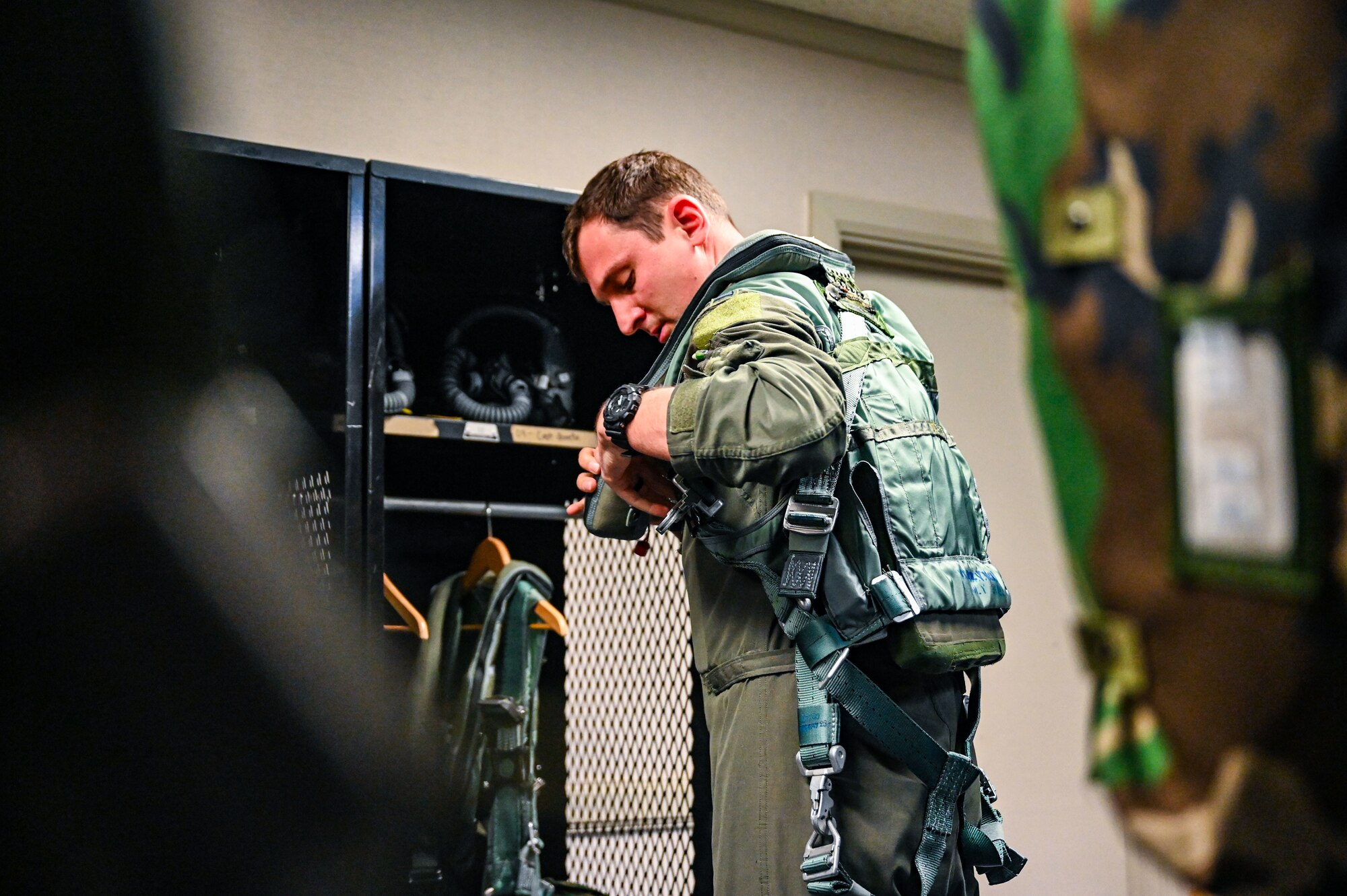 U.S. Air Force 1st Lt. Tyler Goeke, 9th Expeditionary Bomb Squadron weapons system officer, adjusts his PCU 15P harness before taking off for a Bomber Task Force mission at Misawa Air Base, Japan, April 21, 2025. The BTF mission provides opportunities to train and work with our allies and partners in joint and combined operations to discourage aggression and maintain peace and stability in the region and beyond. (U.S. Air Force photo by Airman 1st Class Mattison Cole)