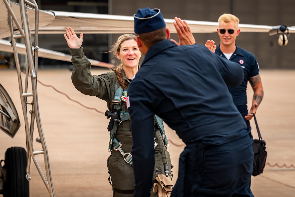 Cari Selzer, Hometown Hero participant, celebrates with U.S. Air Force Lt. Col. Taylor Wight, Thunderbird Seven, Director of Operations for the U.S. Air Force Air Demonstration Squadron "Thunderbirds", after completing an incentive flight at Dyess Air Force Base, Texas, April 18, 2025. Selzer has dedicated her time and skills to international medical missions, both in Kenya and the Philippines, providing essential care and education to hundreds in need. (U.S. Air Force photo by Staff Sgt. Leon Redfern)