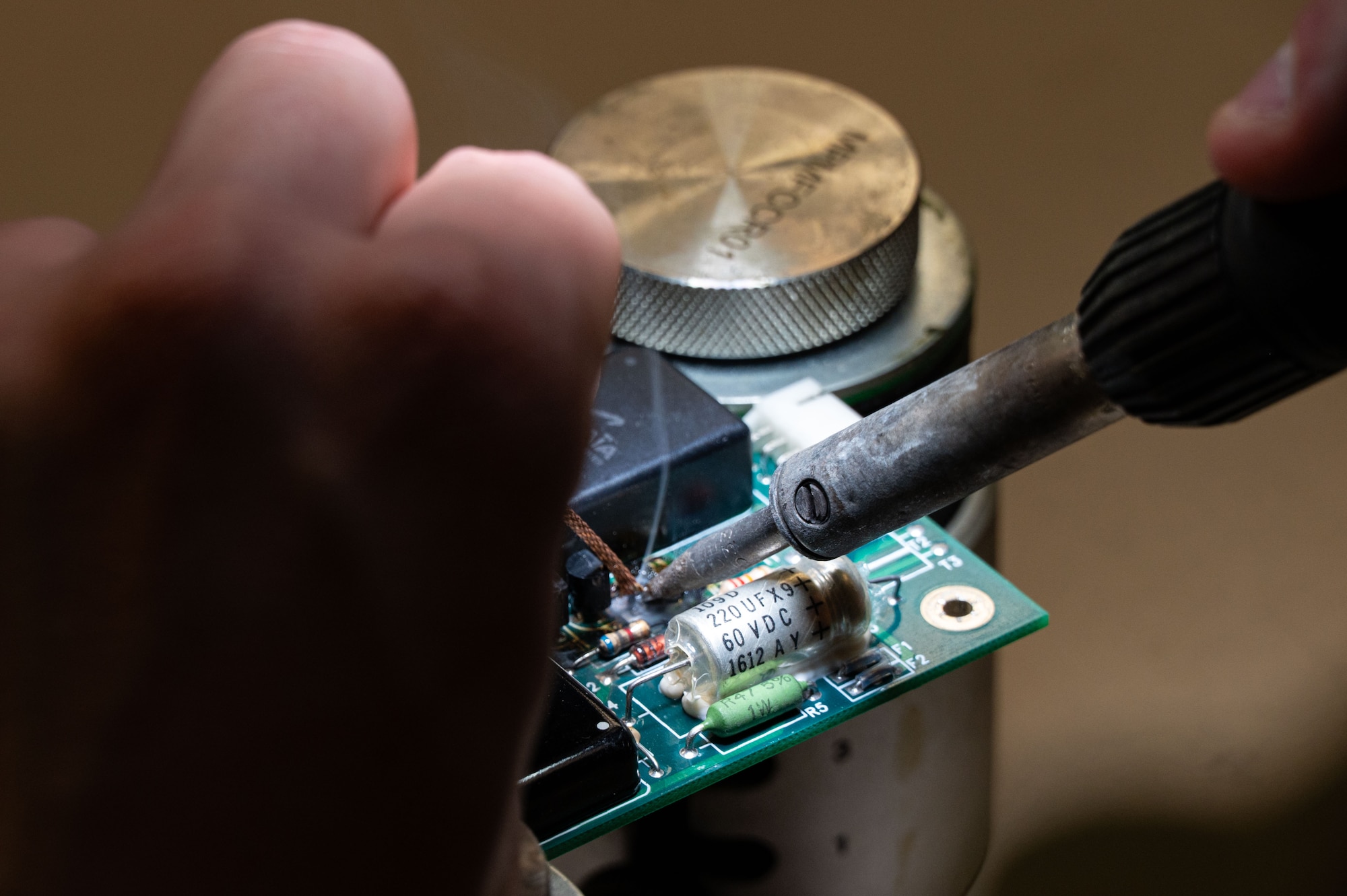 A micro solder is used to repair a circuit board 