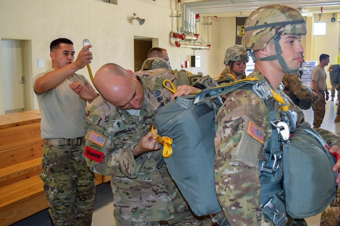 Chaplain Richard Barfield conducts an inspection check on a fellow 173rd Army Airborne Brigade soldier’s chute at Caserma Ederle Army Base, Italy.