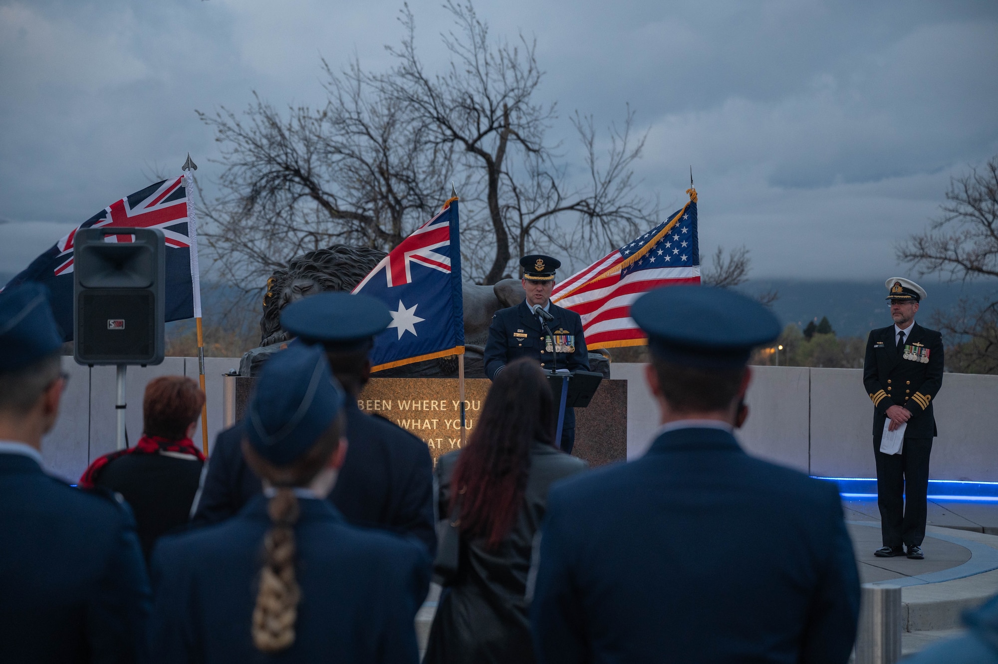 Servicemembers watch as Col. Edgar Gonzalez gives a speech.