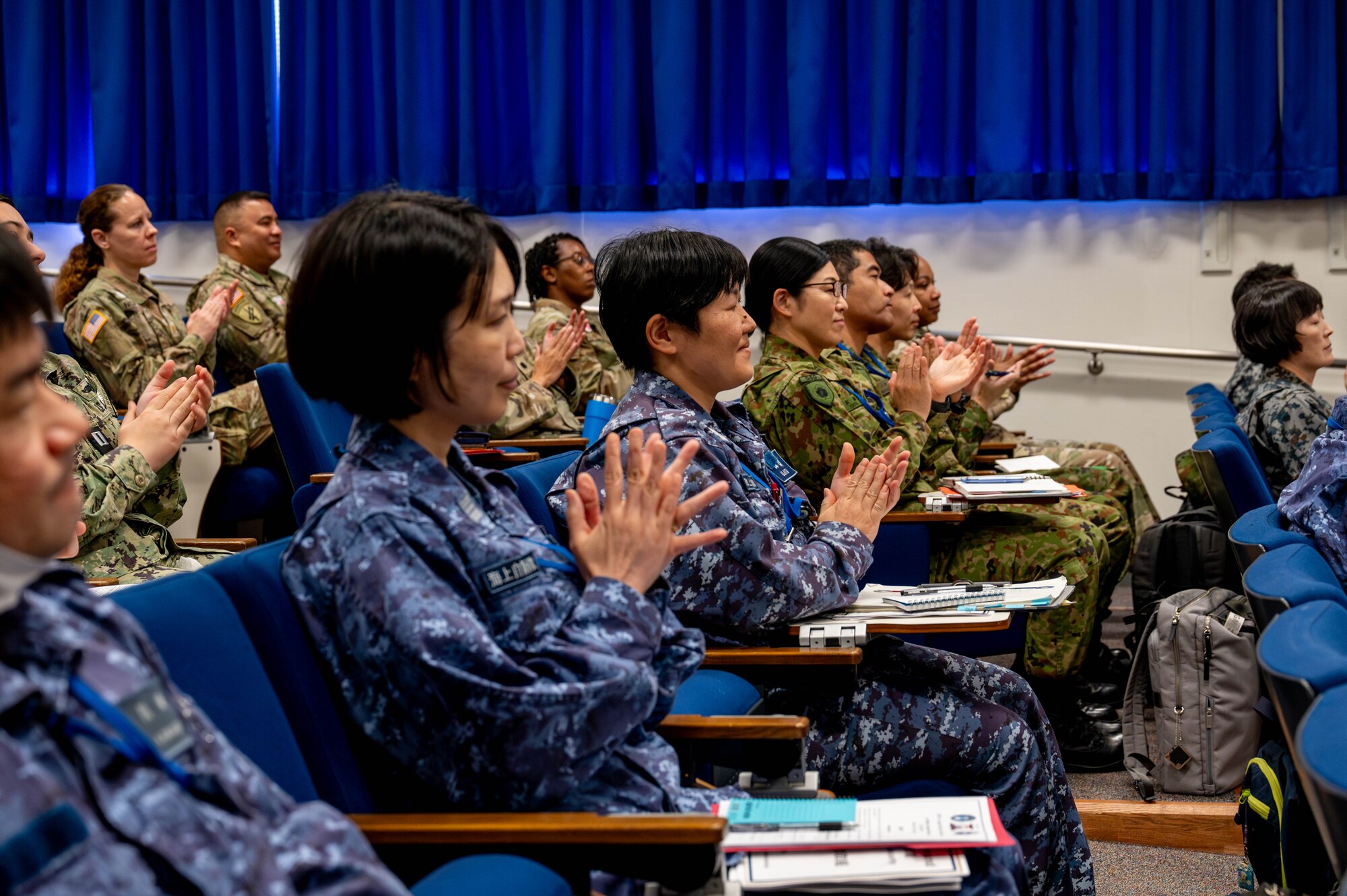 U.S. and Japan military personnel applaud.