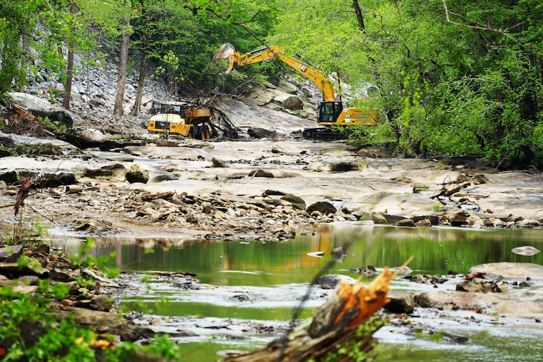 An excavator loads debris into a rock truck as branches, trees and other debris caused by Hurricane Helene is removed from the Broad River near the town of Lake Lure, North Carolina, on April 25, 2025.