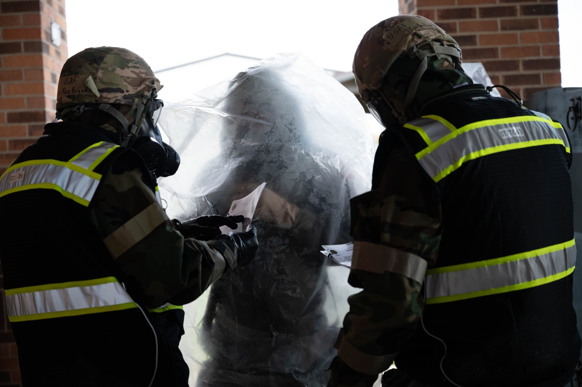 U.S. Air Force Airmen assigned to the 434th Air Refueling Wing walk through a decontamination checklist during the Hoosier Dawn exercise