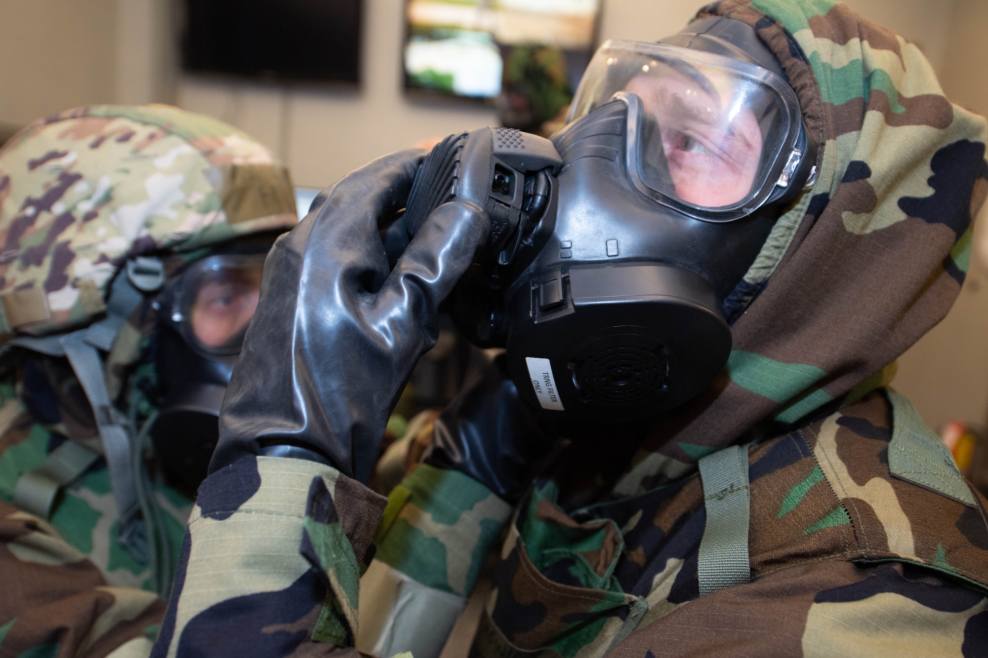 Two command post controllers with the 434th Air Refueling Wing put on their gas masks and perform buddy checks