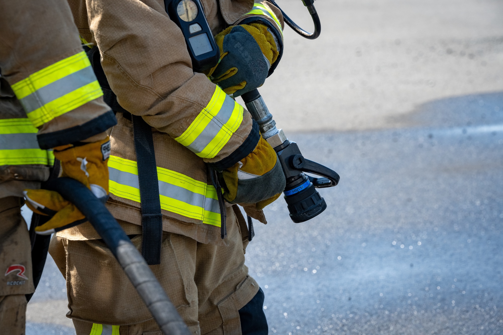 Firefighters prepare to spray burning aircraft.