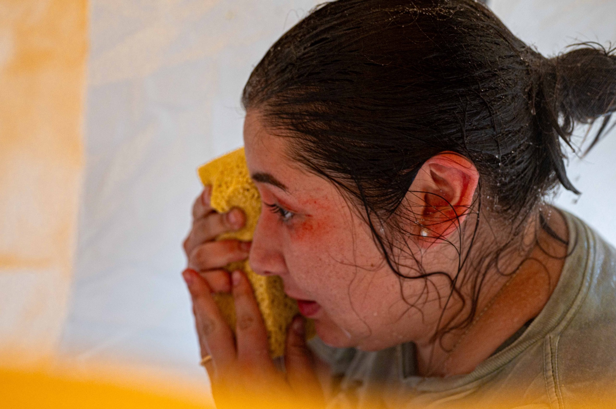 A simulated patient decontaminates herself during a patient casualty care flow at the 18th Medical Group building in support of a health service medical reserve exercise at Kadena Air Base, Japan, April 17, 2025.
