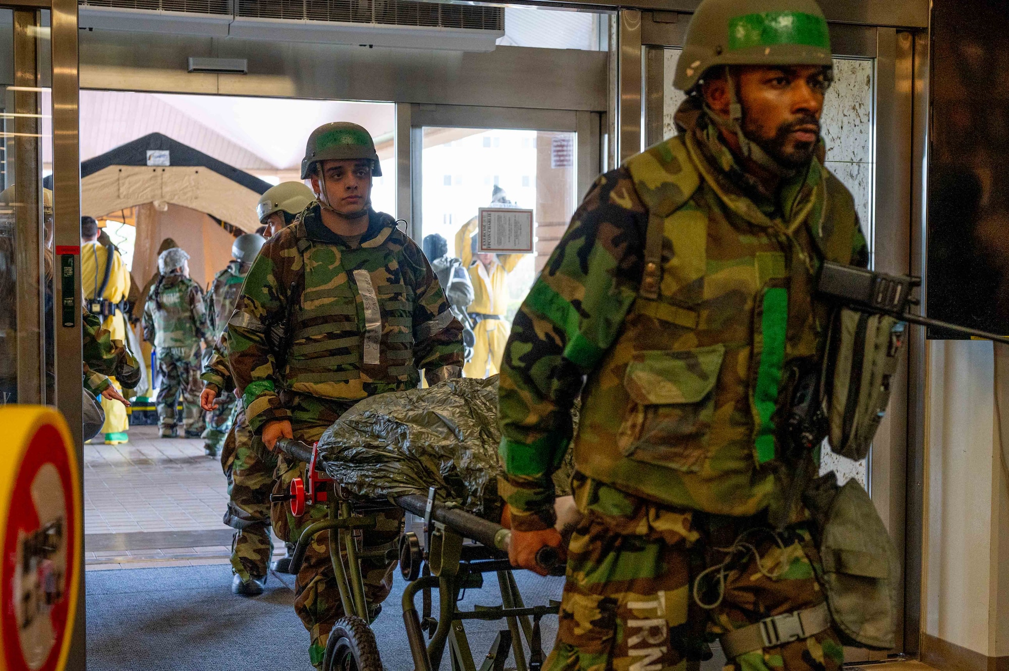 Airmen assigned to the 18th Medical Group transfer a simulated patient after decontamination during a casualty care flow at the 18th Medical Group building in support of a health service medical reserve exercise at Kadena Air Base, Japan, April 17, 2025.