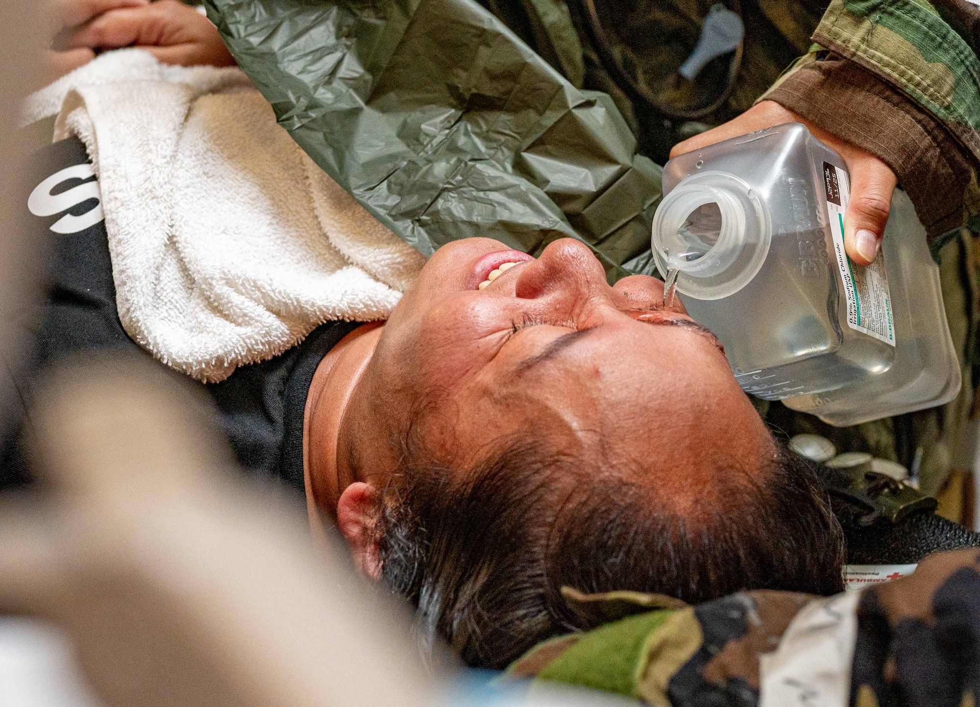 An Airman assigned to the 18th Medical Group flushes a simulated patient’s eyes after decontamination during a casualty care flow at the 18th Medical Group building in support of a health service medical reserve exercise at Kadena Air Base, Japan, April 17, 2025