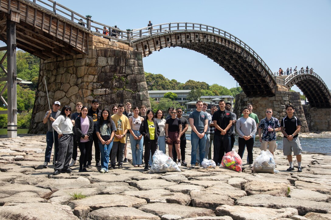 Volunteers from Marine Corps Air Station Iwakuni pose for a group photo after picking up trash during a clean-up at the Kintaikyo Bridge, Iwakuni, Japan, April 21, 2025. The Marine Corps Community Services Iwakuni, Single Marine Program hosted a bridge clean-up as part of the SMP Days of Service, a five-day series of events where service members from Marine Corps Air Station Iwakuni volunteer to build stronger relationships and give back to the community. (U.S. Marine Corps photo by Sgt. Randall Whiteman)