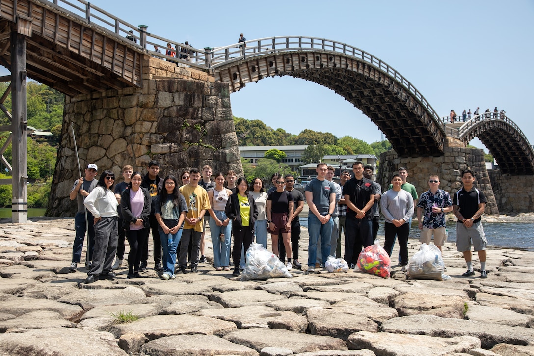 Volunteers from Marine Corps Air Station Iwakuni pose for a group photo after picking up trash during a clean-up at the Kintaikyo Bridge, Iwakuni, Japan, April 21, 2025. The Marine Corps Community Services Iwakuni, Single Marine Program hosted a bridge clean-up as part of the SMP Days of Service, a five-day series of events where service members from Marine Corps Air Station Iwakuni volunteer to build stronger relationships and give back to the community. (U.S. Marine Corps photo by Sgt. Randall Whiteman)