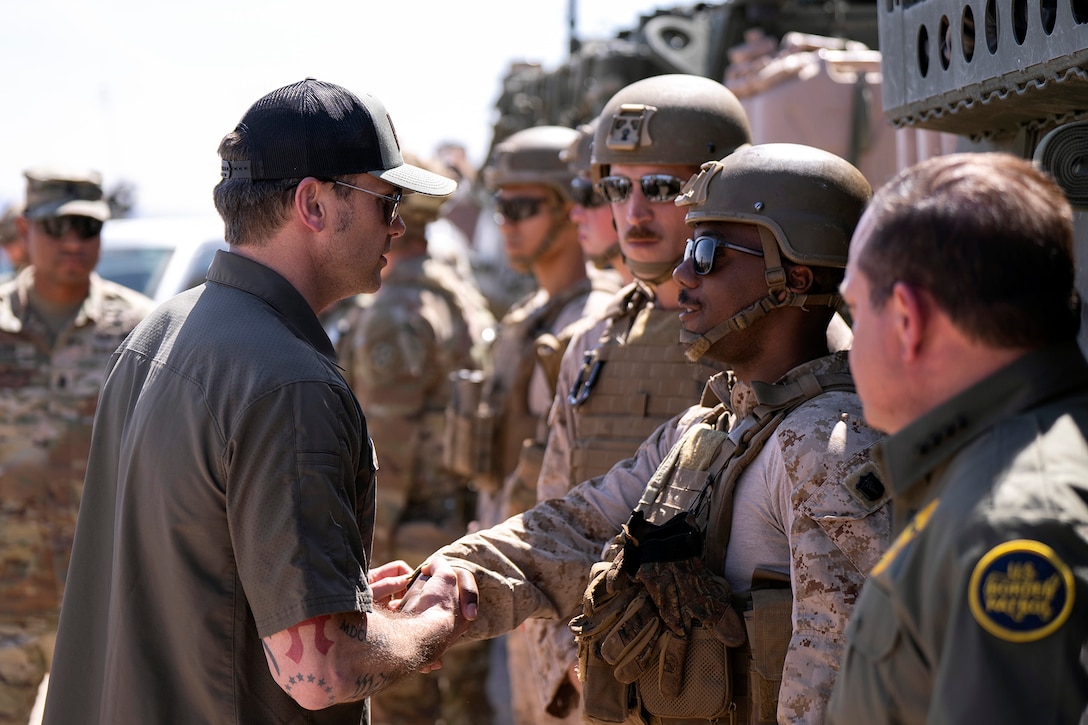 The defense secretary greets troops.