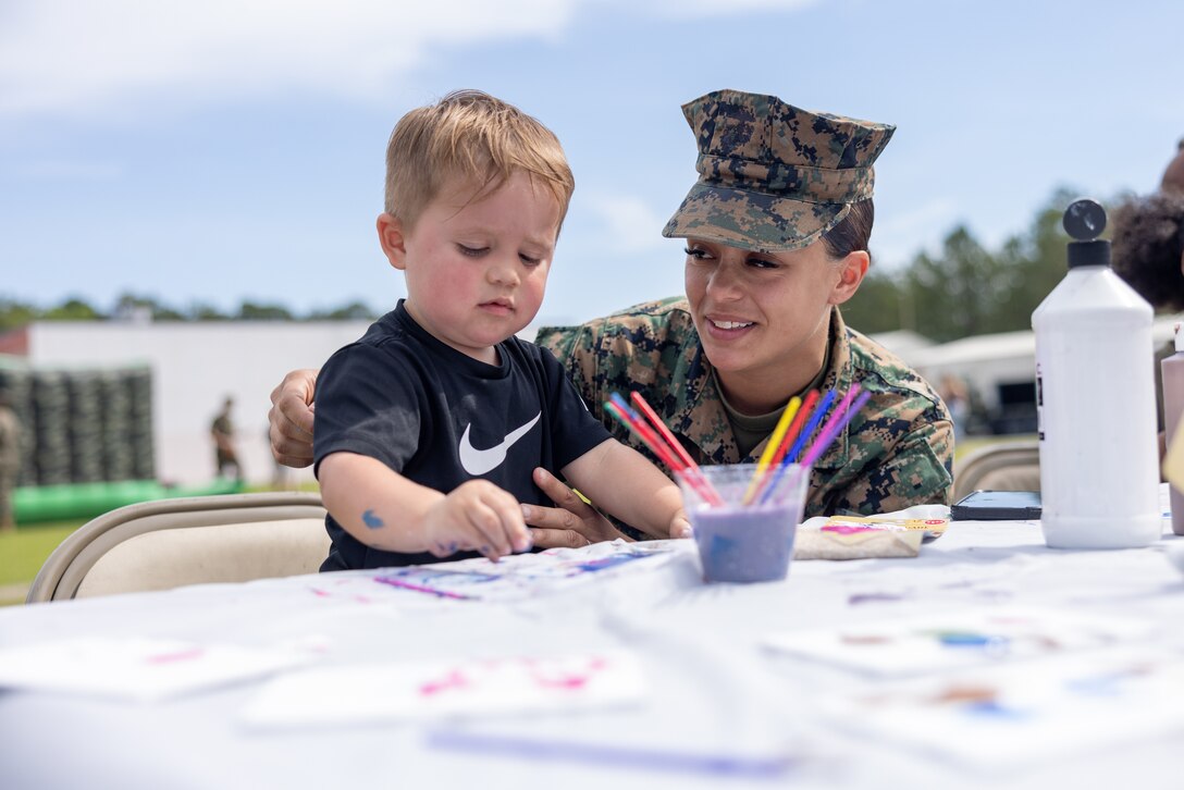 A U.S. Marine with 2nd Combat Readiness Regiment, 2nd Marine Logistics Group, and her son participate in a finger-painting event during a regimental family day on Marine Corps Base Camp Lejeune, North Carolina, April 24, 2025. 2d Maintenance Battalion and 2nd CRR co-hosted the field day event in honor of the Month of the Military Child Appreciation to celebrate our children and build camaraderie. (U.S. Marine Corps photo by Cpl. Christian Salazar)