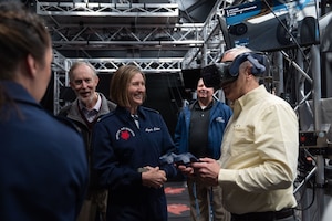 Col. Angela Ochoa, 89th Airlift Wing commander, assists honorary commanders and Andrews Ambassadors with operating a virtual reality headset during an Honorary Commander immersion tour of the 89th Airlift Wing at Joint Base Andrews, Maryland, April 8, 2025. Attendees received a one-of-a-kind mission brief, a hands-on virtual reality headset experience walking through our aircraft, and toured a C-37 and C-40 aircraft. (U.S. Air Force photo by Staff Sgt. Gabrielle Winn)