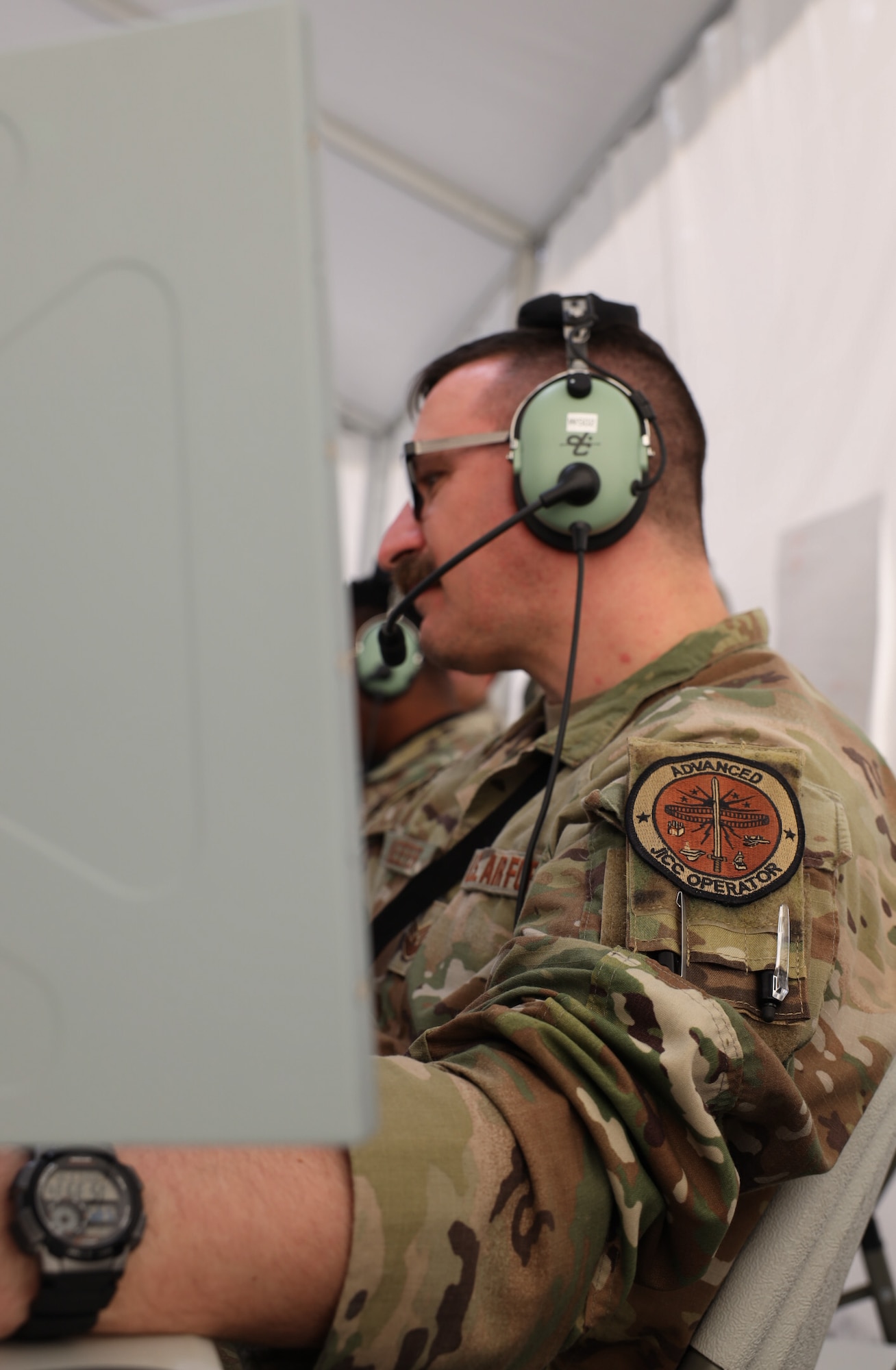 Tech. Sgt. Timothy Keefer reviews information provided to him by the air battle manager during Project Convergence Capstone 5 at the National Training Center, Fort Irwin, California, March 10, 2025. Keefer, a weapons and tactics flight chief for the 752nd Operations Support Squadron, participated in the event as an advanced Joint Interface Control Center operator. An AJOC is responsible for troubleshooting and configuring joint tactical data links, ensuring a smooth exchange of information while maintaining a common tactical picture for all participating forces in the experiment. (Official Air Force photo by Morgan Brown)