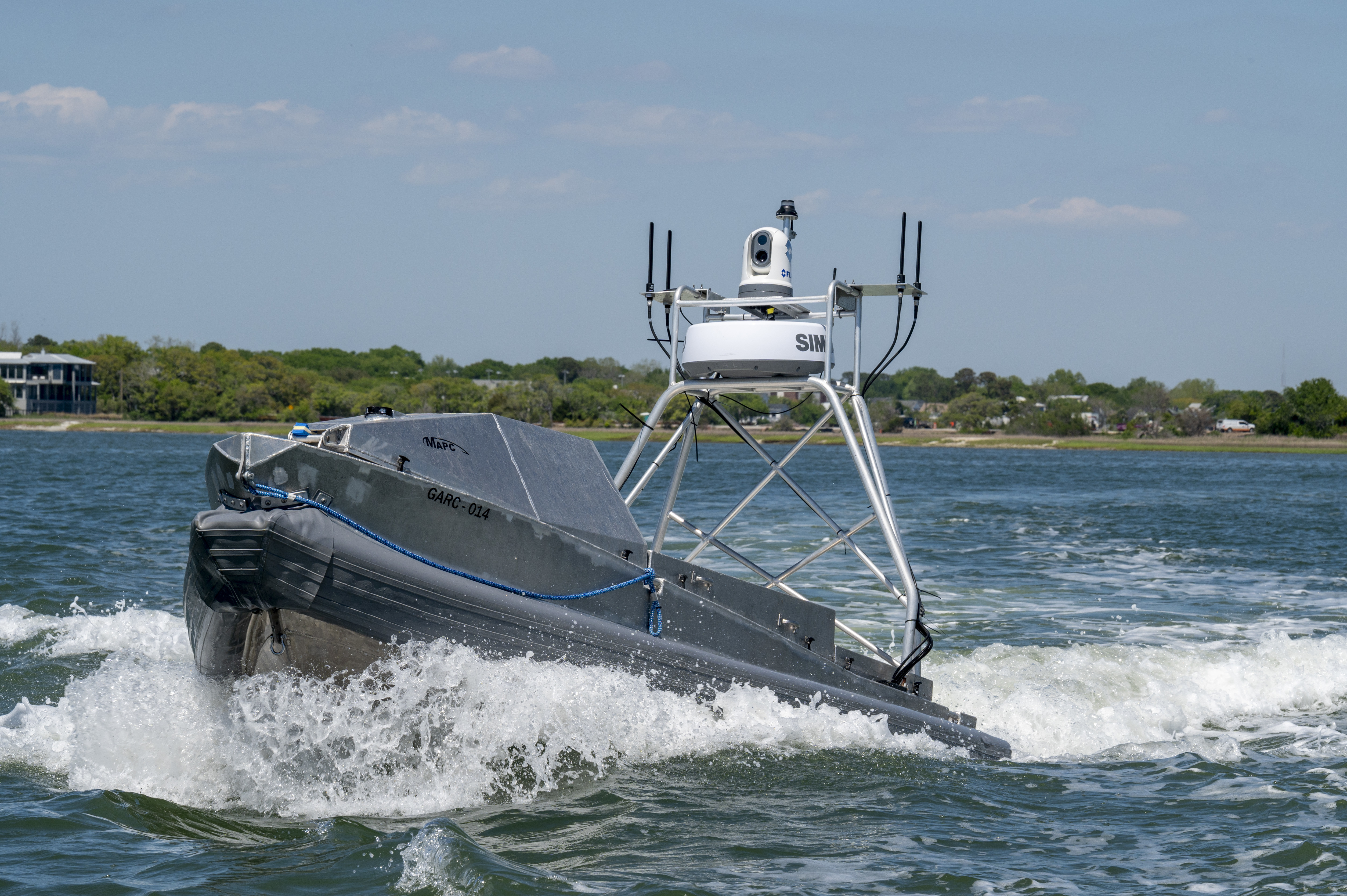 A photo of a Unmanned Autonomous System Boat moving in the water.