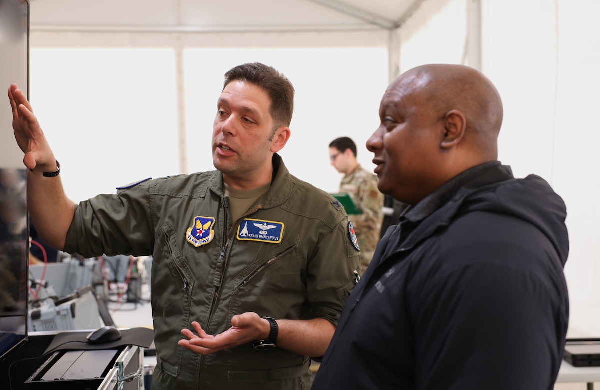 Col. Frank Biancardi II, deputy director for Advance Battle Management System Cross Functional Team, discusses the progress of the tactical operations center-light with Mark Phillips, during Project Convergence Capstone 5 at the National Training Center, Fort Irwin, California, March 11, 2025. Phillips, as the deputy for Joint Force Integration, Joint Staff, provides collaboration and integration of joint force development and design by identifying future concepts that address emerging, future joint operational challenges and required capabilities. (Official Air Force photo by Morgan Brown)