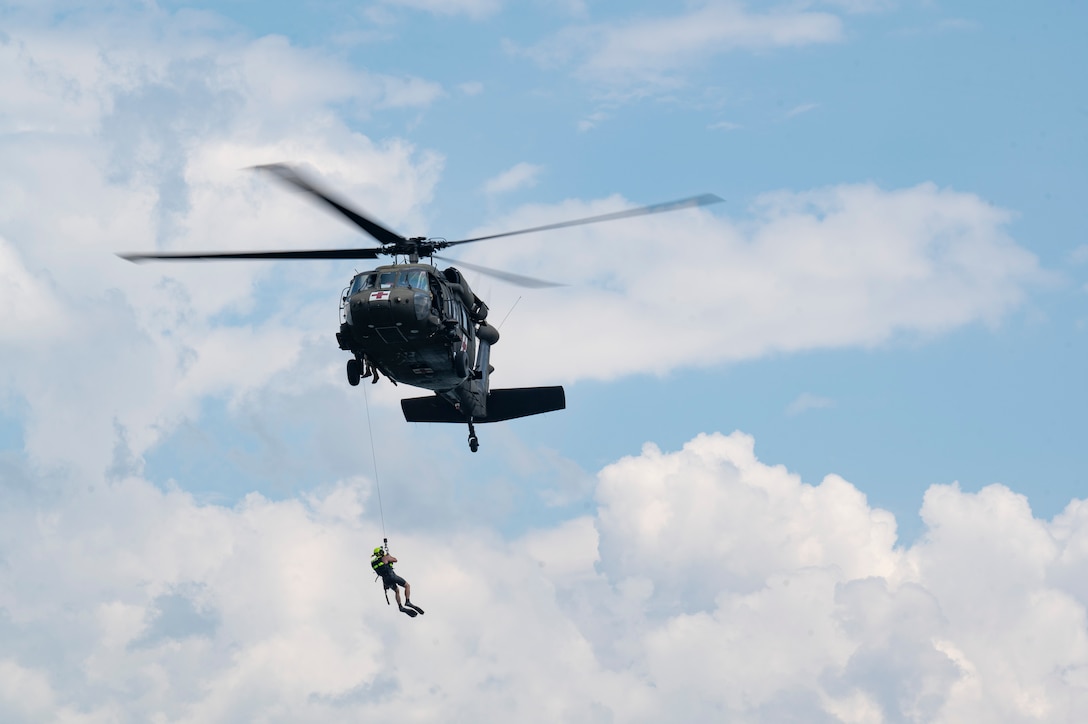 U.S. Army Staff Sgt. James Fernald, United States Army Air Ambulance Detachment (USAAAD), 1st Battalion, 228th Aviation Regiment Joint Task Force-Bravo critical care flight paramedic, is hoisted by a HH-60L Black Hawk assigned to the 1-228th, during a simulated overwater hoist rescue at Lake Yojoa, Honduras, April 22, 2025. The drills ensured members of the 1-228th could sharpen their skills and be prepared to work alongside the U.S.’s Honduran and Central American partners in case of a natural disaster. (U.S. Air Force photo by Staff Sgt. Sadie Colbert)